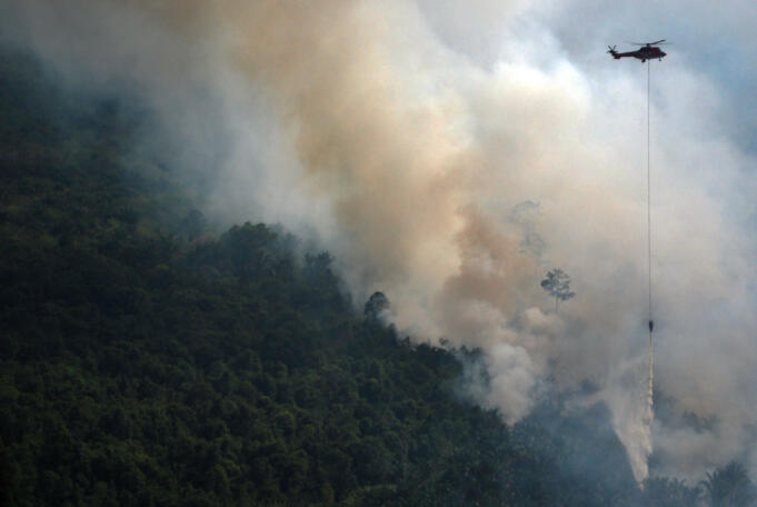 Helikopter Superpuma Sinar Mas Forestry melakukan pengeboman air (water boombing) di atas hutan yang terbakar di Desa Bokor, Kabupaten Kepulauan Meranti, Riau, Selasa (15/3)