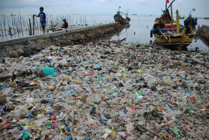 Dua orang anak bermain di samping tumpukan sampah di kawasan pesisir laut, Kelurahan Cangkol Tengah, Lemahwungkuk, Cirebon, Jawa Barat, Senin (16/5). Kondisi penumpukan sampah tersebut menyebabkan kondisi air laut tercemar yang berdampak buruk bagi biota l