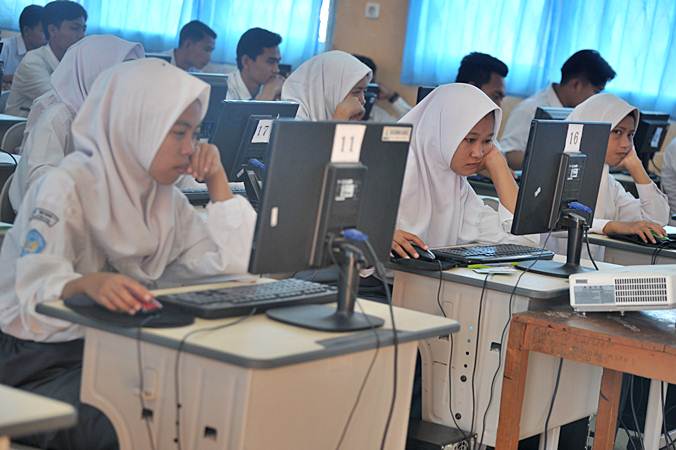 Sejumlah siswa mengerjakan soal pada Ujian Nasional Berbasis Komputer (UNBK) Sekolah Menengah Atas Kejuruan (SMK) di ruang komputer Gedung SMK Negeri 7 Palembang, Sumatera Selatan, Senin (25/3/2019).